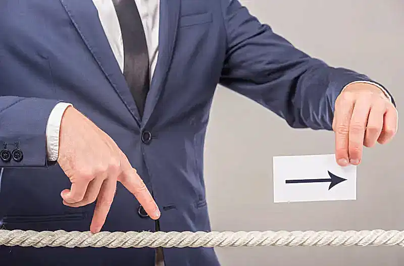 Takım elbiseli kişi ileri yönü gösteren ok tutuyor – 2025 doçentlik başvuru süreci, puanlama sistemi ve jüri değerlendirmesi.