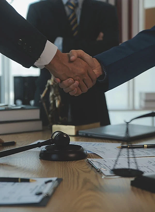 Bir hukuk ofisinde, el ele sıkışan avukat ve müvekkil.
