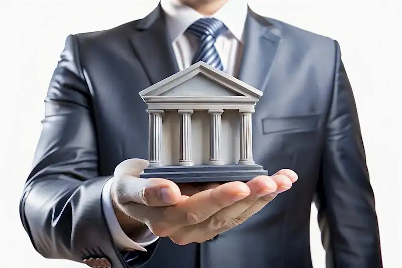 Takım elbiseli kişi elinde adliye biçiminde banka maketi tutuyor – kredi sözleşmeleri, dosya masrafları ve bankacılık hukuku danışmanlığı.