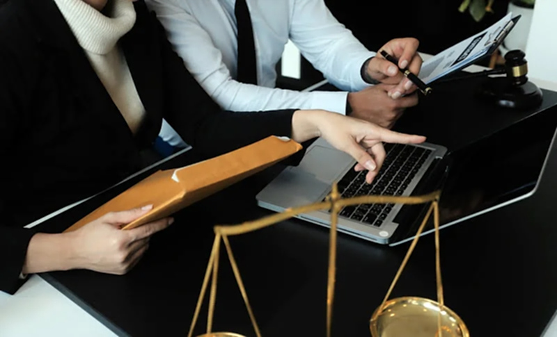 Yasal belgeleri ve dijital verileri inceleyerek doğru hukuki stratejileri belirleyen avukatların yer aldığı, adalet sembolleriyle zenginleştirilmiş görsel.