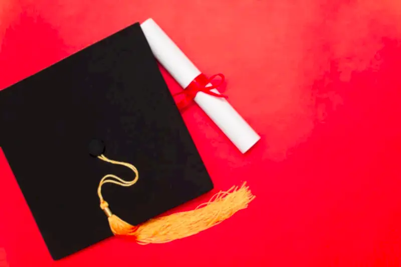 Kırmızı zemin üzerinde mezuniyet kepi ve diploma – doçentlik unvanı iptali, etik ihlal ve sahtecilik süreçleri.