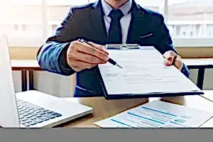 Resmi belgeyi gösteren takım elbiseli kişi – akademik etik kurul savunması hazırlama süreci ve itiraz yolları.