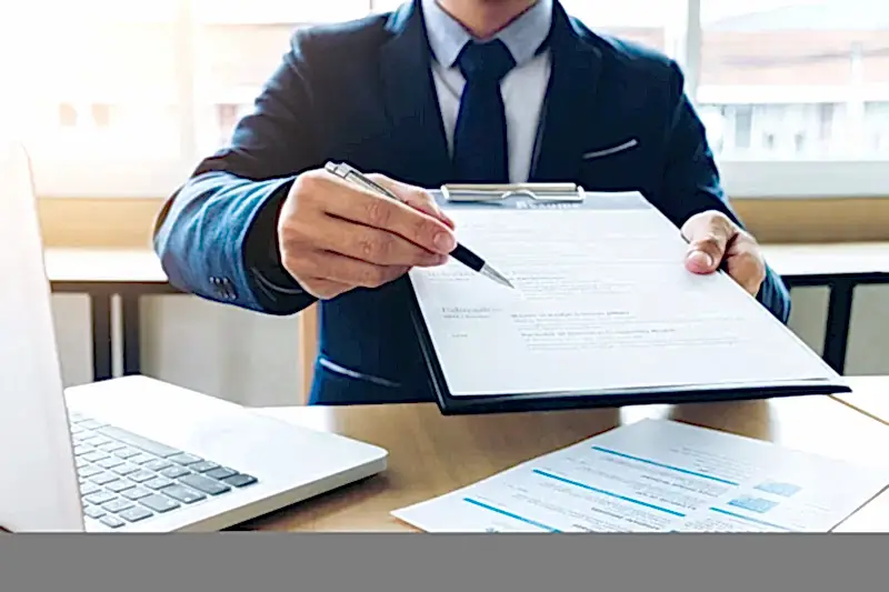 Resmi belgeyi gösteren takım elbiseli kişi – akademik etik kurul savunması hazırlama süreci ve itiraz yolları.