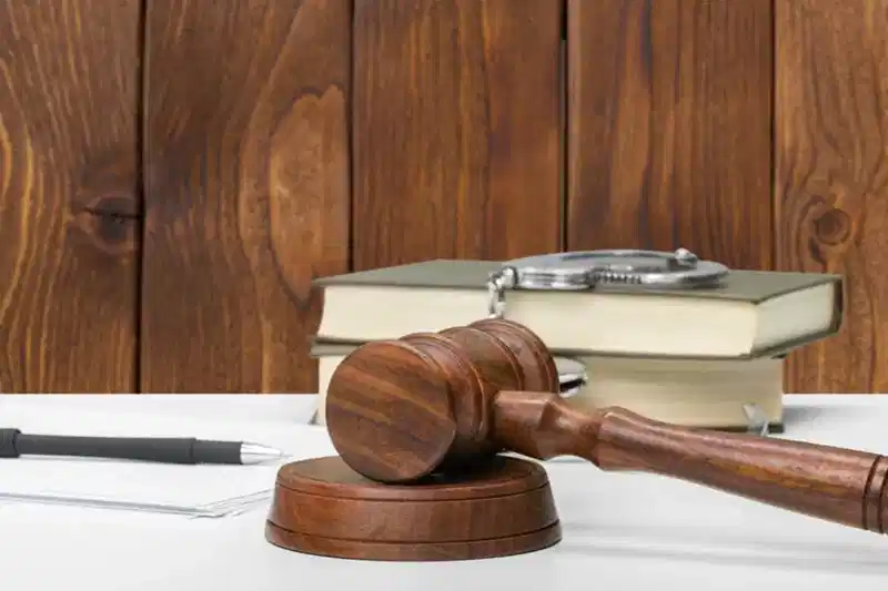 Masada yargı tokmağı, kitaplar ve kelepçe – idari işlemlerden doğan hukuki uyuşmazlıklar ve dava süreçleri.