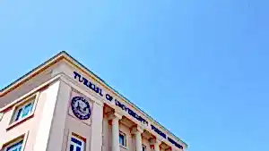 Tabelasında "Turkish University" yazan bir bina ve mavi gökyüzü.